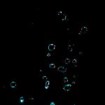 Captivating photo of water bubbles suspended in motion against a dark background.